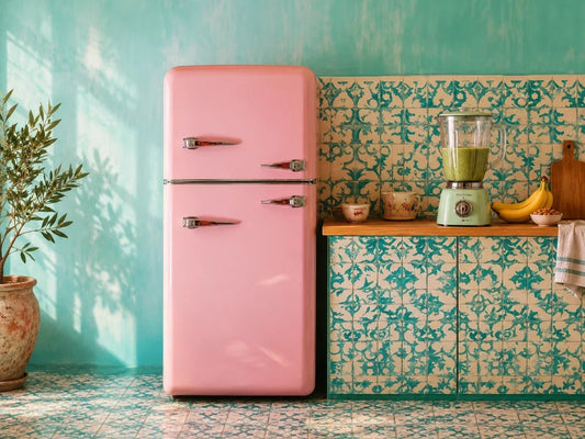 Sunlit pastel kitchen with a pink refrigerator and a blender holding a green smoothie.
