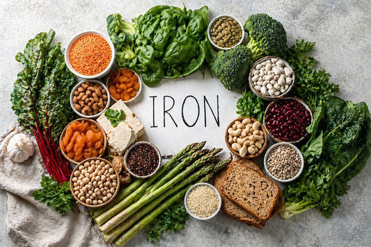 Top-down view of iron-rich plant foods arranged alongside vitamin C foods to illustrate absorption pairing